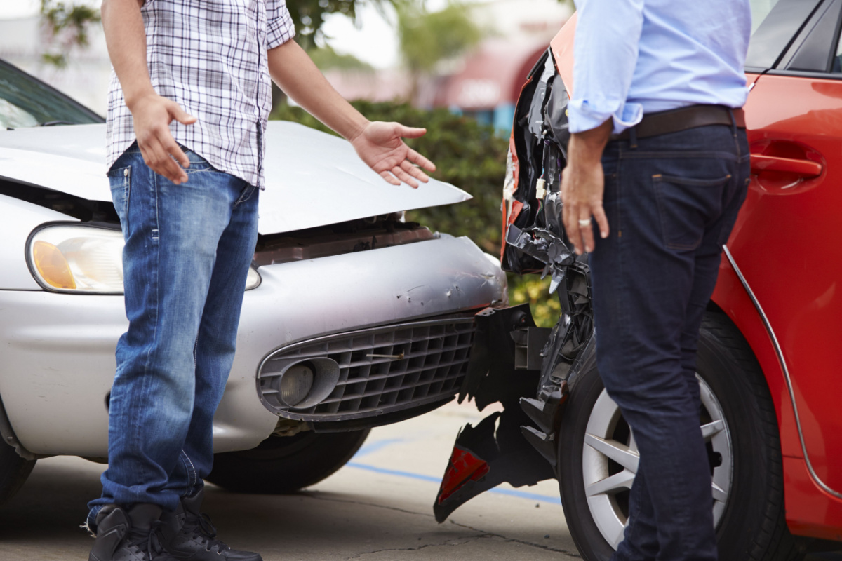 Drivers standing next to damaged cars 