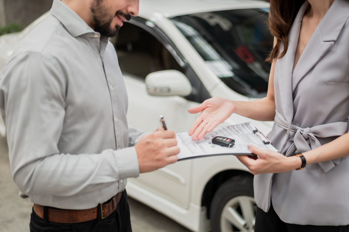 Driver signing new car lease paperwork