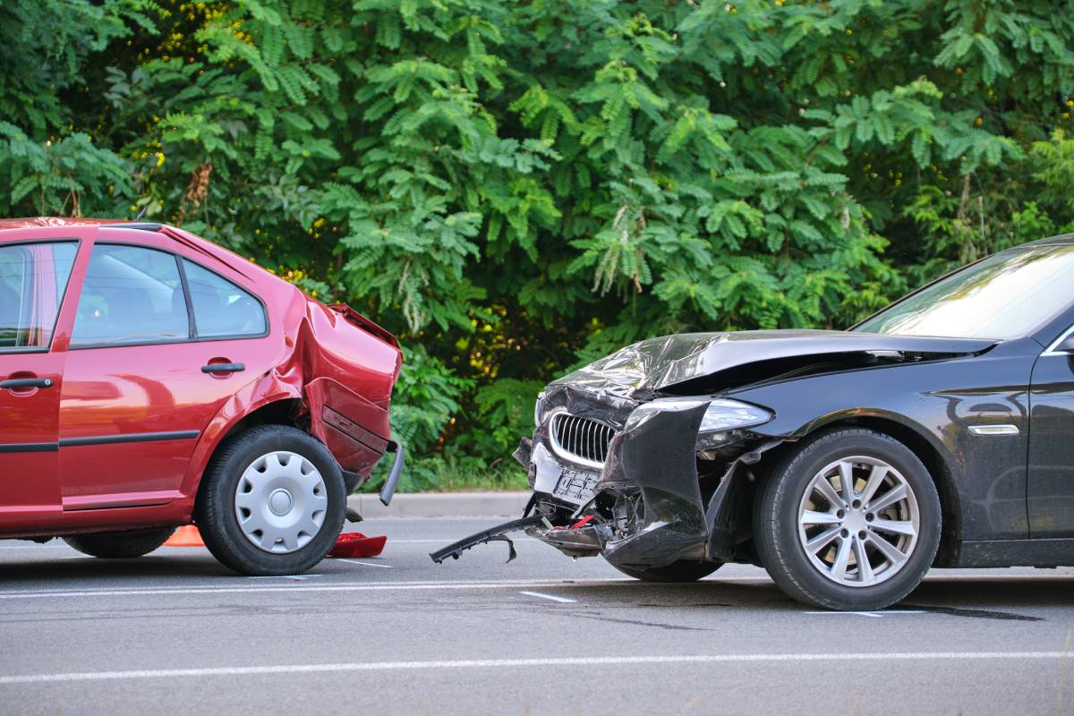 a red car rear ended by a totaled black car in an accident